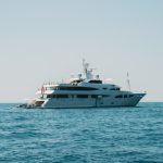 A large luxury yacht sailing on clear blue waters under a clear sky